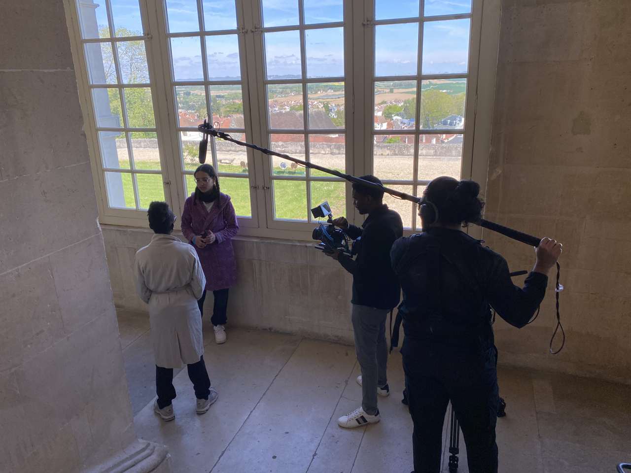 Élèves en tournage avec caméra et perche dans un château
